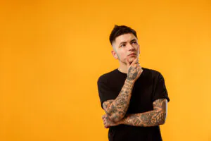Homem pensando remoção de tatuagem
